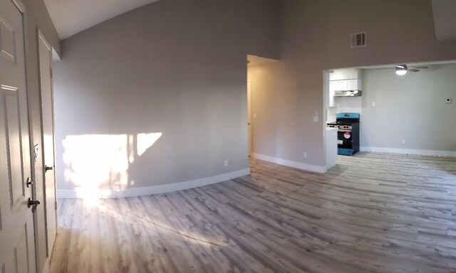 unfurnished living room featuring lofted ceiling, ceiling fan, and light hardwood / wood-style floors