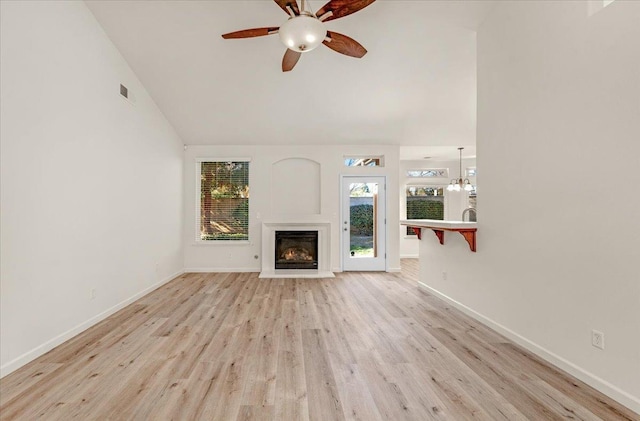 unfurnished living room with lofted ceiling, ceiling fan, and light hardwood / wood-style floors