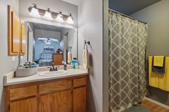bathroom featuring hardwood / wood-style flooring, vanity, ceiling fan, and a shower with shower curtain