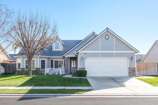 view of front of home featuring a front yard, covered porch, and a garage