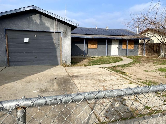 view of front of home featuring a garage and solar panels