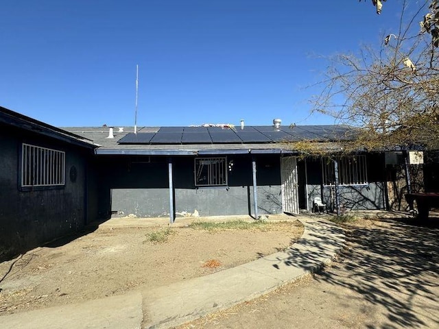 rear view of house featuring solar panels