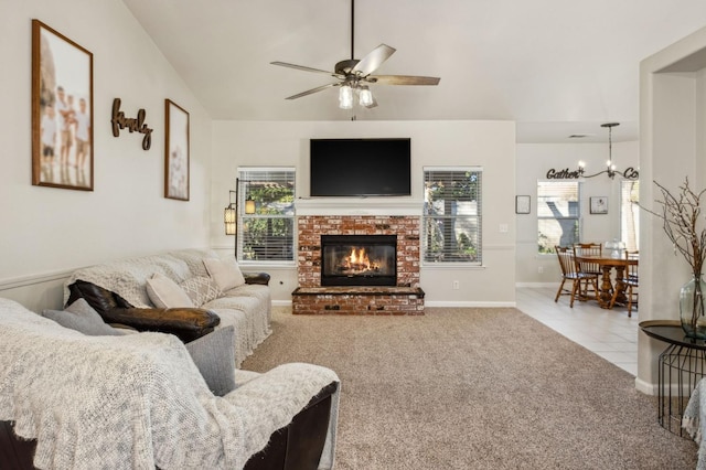 living room featuring light carpet, a brick fireplace, and ceiling fan with notable chandelier