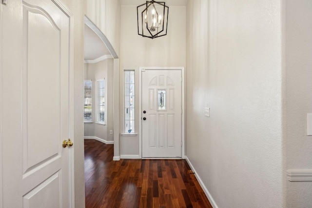 foyer entrance featuring an inviting chandelier and dark hardwood / wood-style floors