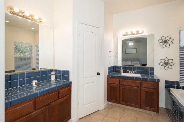 bathroom with vanity, tile patterned flooring, and a relaxing tiled tub