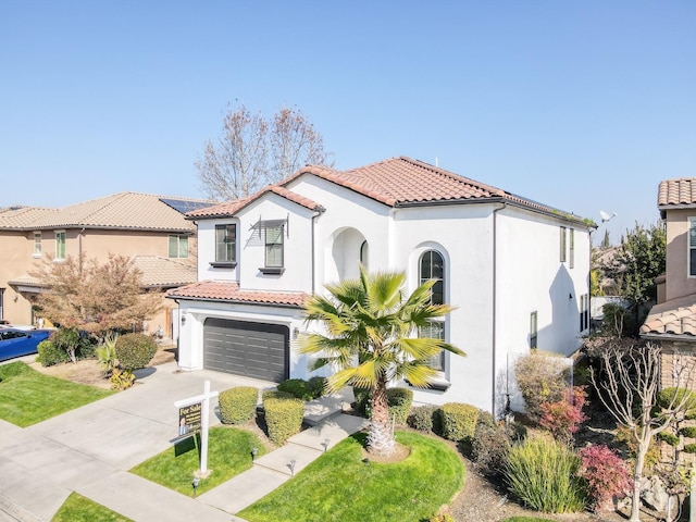 mediterranean / spanish-style home featuring a garage and a front yard