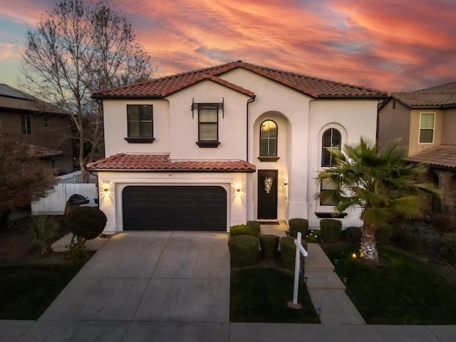 mediterranean / spanish home with a garage