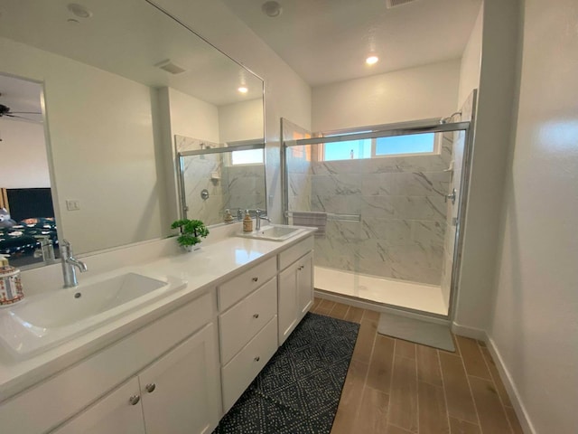 bathroom with vanity and a shower with door