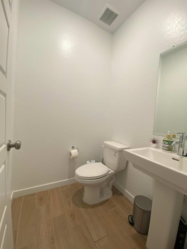 bathroom featuring toilet and hardwood / wood-style flooring