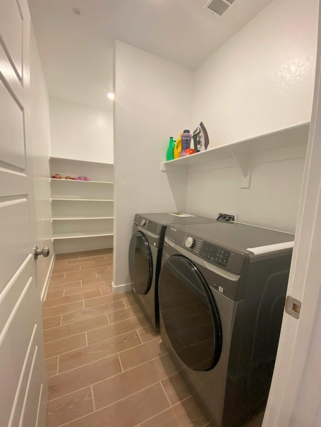 washroom featuring wood-type flooring and independent washer and dryer