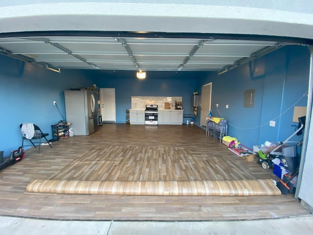 garage with electric panel and stainless steel fridge