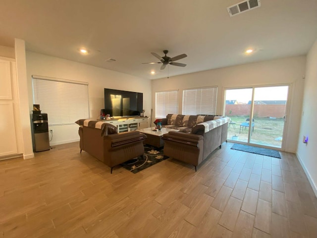 living room with ceiling fan and light hardwood / wood-style floors