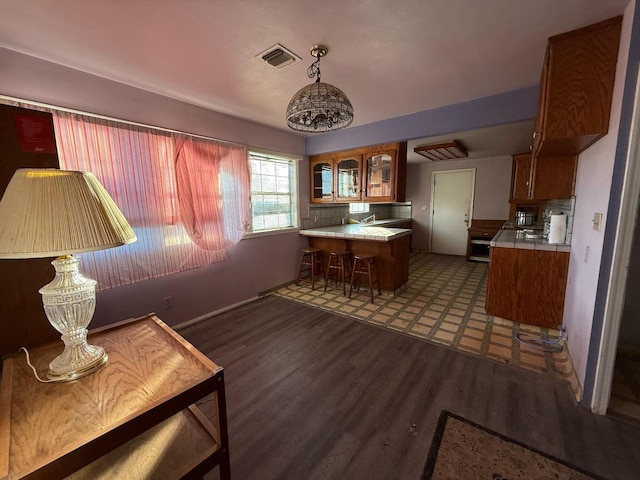 kitchen featuring kitchen peninsula, tile counters, and dark hardwood / wood-style flooring