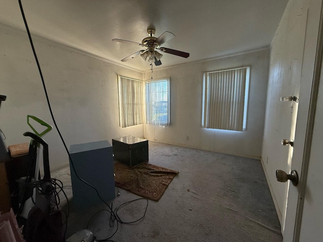 carpeted empty room featuring ceiling fan and ornamental molding