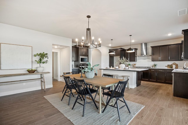 dining space with wood-type flooring and a notable chandelier