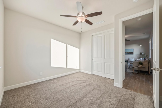 carpeted bedroom featuring ceiling fan and a closet