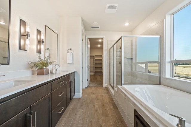 bathroom featuring shower with separate bathtub, hardwood / wood-style flooring, and vanity