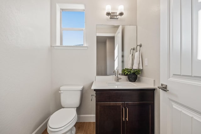 bathroom featuring toilet, hardwood / wood-style flooring, and vanity