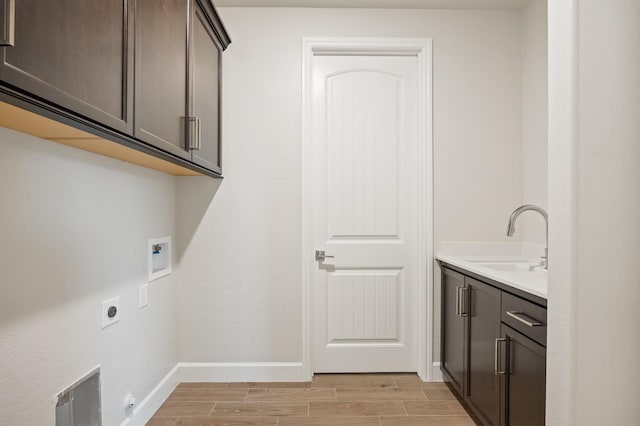 clothes washing area featuring washer hookup, cabinets, sink, and hookup for an electric dryer