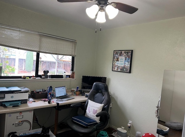 office space featuring a ceiling fan and baseboards