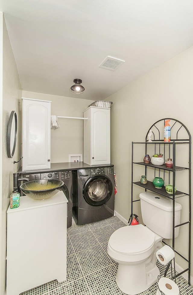 bathroom with tile patterned flooring, toilet, separate washer and dryer, visible vents, and baseboards