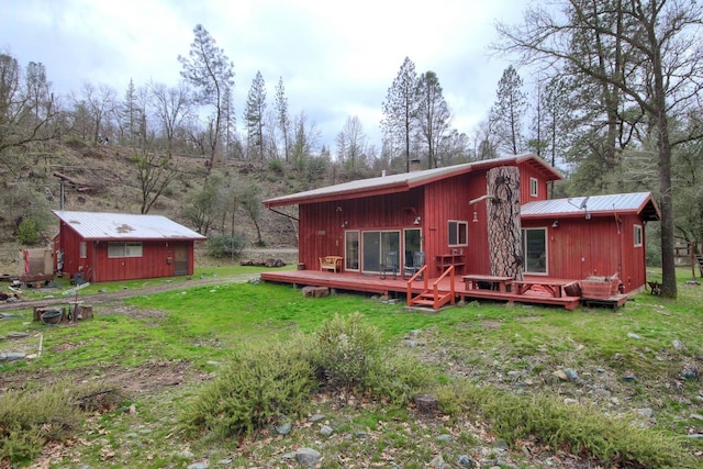 rear view of property featuring a deck and a lawn