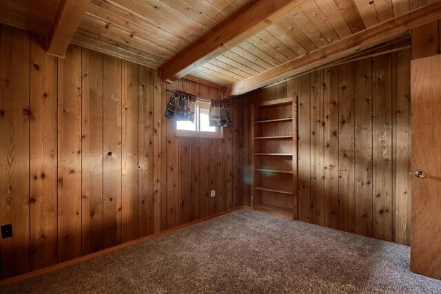 carpeted empty room with wood ceiling, wood walls, and beamed ceiling