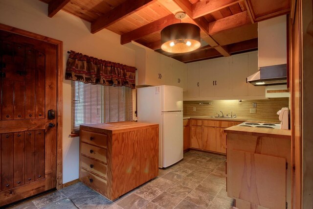 kitchen with white fridge, beam ceiling, decorative backsplash, sink, and butcher block counters