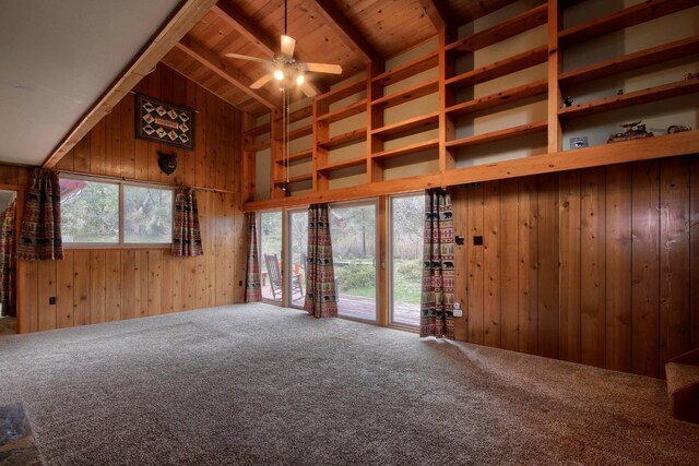 unfurnished living room with wood ceiling, beamed ceiling, wooden walls, and carpet flooring