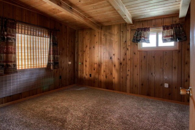 spare room with wood ceiling, wood walls, and beamed ceiling