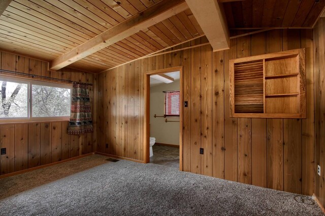 unfurnished room featuring wooden ceiling, carpet floors, wooden walls, and beamed ceiling