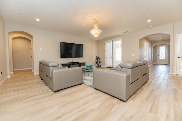 living room featuring a chandelier and light hardwood / wood-style flooring