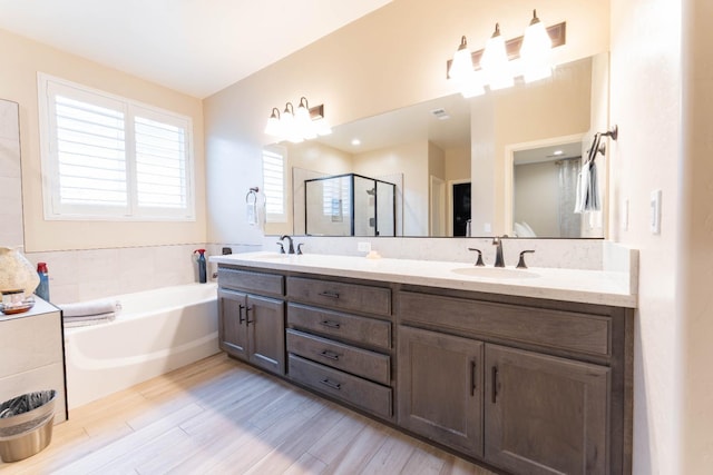 bathroom with vanity, wood-type flooring, and independent shower and bath