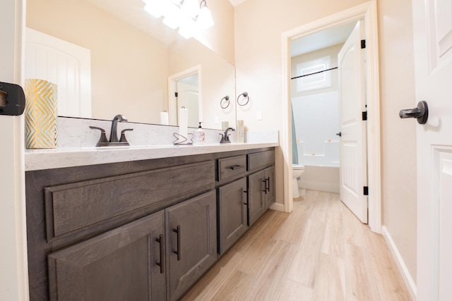 full bathroom featuring wood-type flooring, toilet, shower / tub combination, and vanity