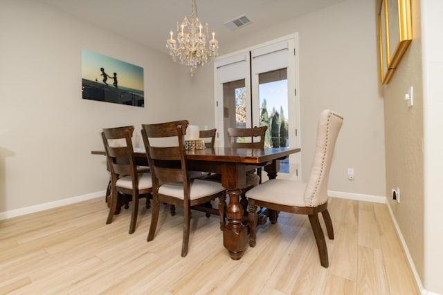 dining area featuring a chandelier and light hardwood / wood-style floors