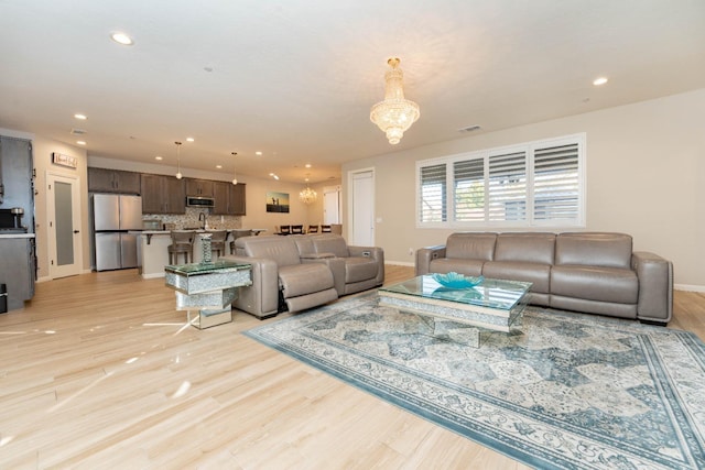 living room featuring a chandelier and light hardwood / wood-style flooring