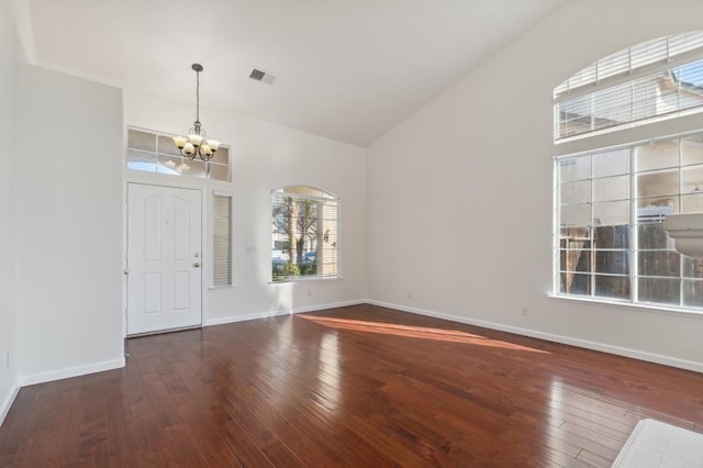 entryway featuring dark wood-type flooring, a chandelier, and high vaulted ceiling