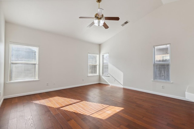 empty room with ceiling fan, a wealth of natural light, and dark hardwood / wood-style flooring