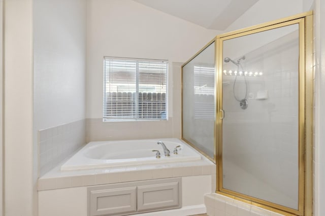 bathroom featuring independent shower and bath and lofted ceiling