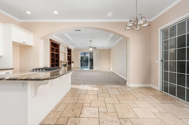 kitchen with stainless steel gas cooktop, dark stone counters, pendant lighting, white cabinets, and a breakfast bar