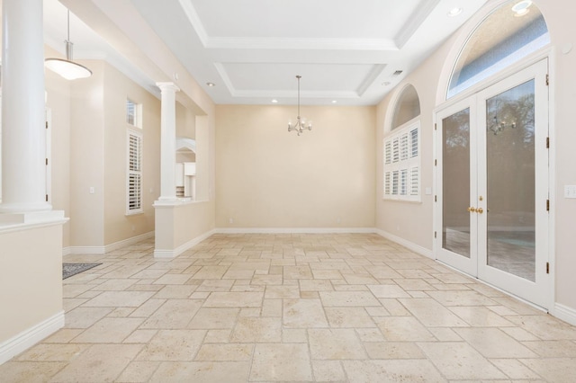 unfurnished room with ornate columns, a chandelier, and french doors