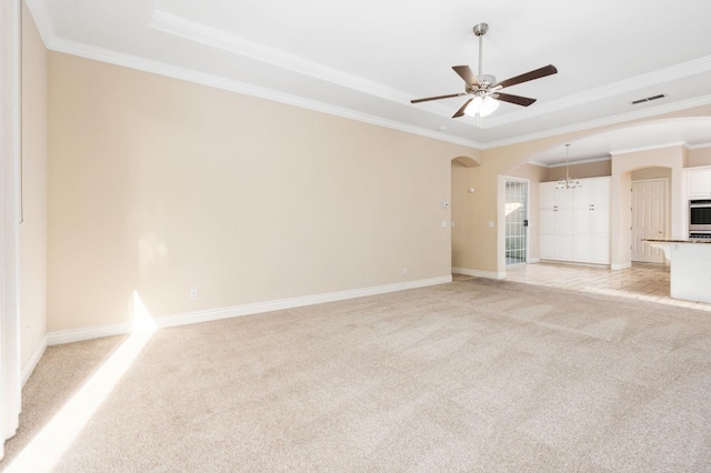 unfurnished living room featuring ceiling fan with notable chandelier, light colored carpet, and ornamental molding