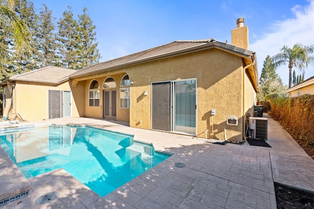 view of pool featuring central air condition unit and a patio