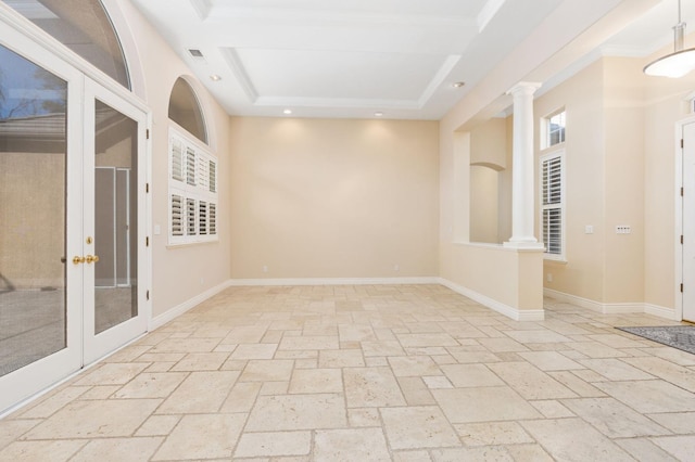 unfurnished room with crown molding, a raised ceiling, and decorative columns