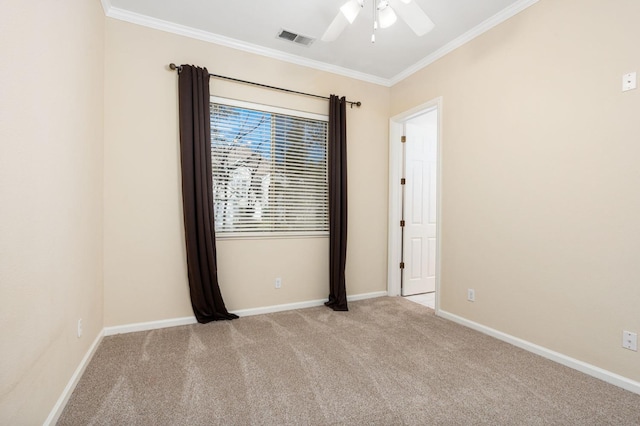 carpeted spare room with ceiling fan and ornamental molding