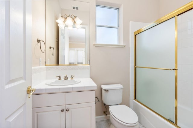 full bathroom with toilet, vanity, and shower / bath combination with glass door