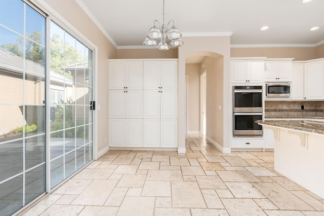 kitchen with stone counters, appliances with stainless steel finishes, white cabinets, and decorative light fixtures