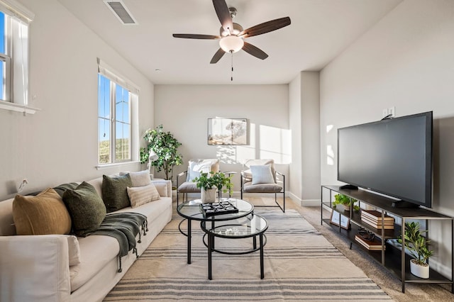 carpeted living room with ceiling fan and plenty of natural light