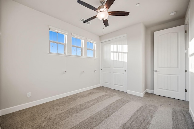 carpeted spare room featuring ceiling fan