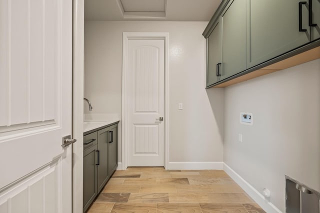 laundry room featuring light wood-type flooring, sink, hookup for a washing machine, and cabinets